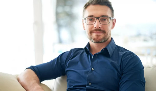 Adult man with eyeglasses sitting on a couch