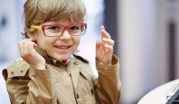 Excited little boy trying on eyeglasses